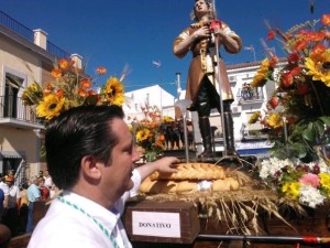 El alcalde de Gibraleón entrega una rosca a San Isidro durante la procesión del pasado año. 