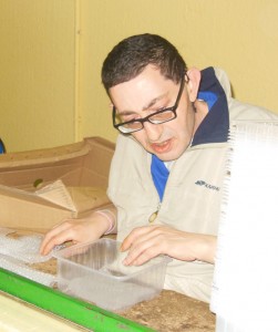 Uno de los trabajadores del centro, Francisco, poniendo las alfombrillas a los envases.