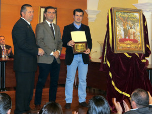 El cartel anunciador de la Semana Santa moguereña fue presentado en un abarrotado Salón de Plenos del Ayuntamiento de Moguer.