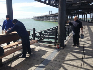 Los operarios realizan las labores de limpieza del Muelle.