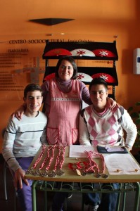 Fali Cartes junto a dos miembros del grupo joven vendiendo las medallas y otros objetos de la Hermandad.