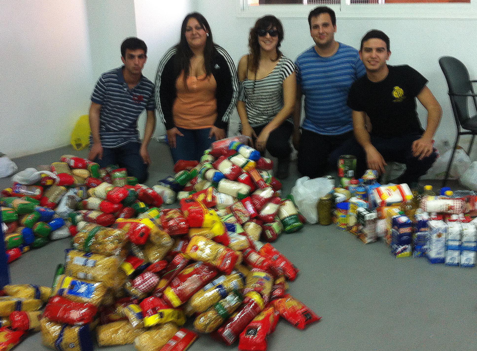 Los jóvenes fundadores de Almacén Solidario junto a alimentos recaudados en una anterior iniciativa.