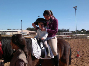 Lorena, a caballo, con uno de los pequeños jinetes.