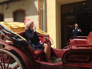 Ataviada para esta especial ocasión Isabel II saluda a los vecinos de San Juan del Puerto.