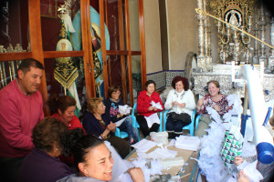 El grupo de mujeres voluntarias que se encargan de preparar los adornos de la calle Virgen del Rocío. / Foto: Juan Antonio Ruiz. 