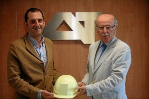 Los representantes de Presistem y IAT con un ejemplar del casco minero inteligente.