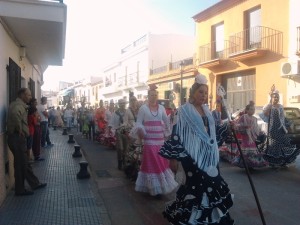 La comitiva de romeros acompañan a su Simpecado en la salida del pueblo.