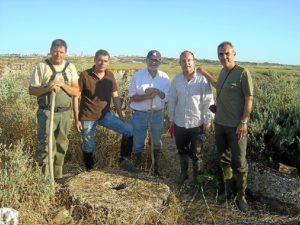 Componentes de la expedición junto a una piedra hallada del molino de marea.