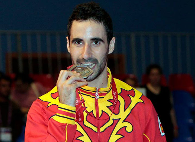 Pablo Abián muerde su medalla de plata, primera del bádminton español en unos Juegos del Mediterráneo. / Foto: COE.