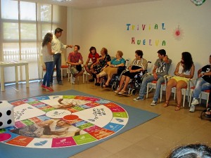 Mayores y jóvenes en torno al trivial central.