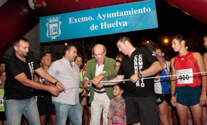 Momento en el que el alcalde de Huelva, Pedro Rodríguez, corta la cinta para dar la salida a la carrera.