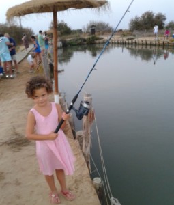 Una menor disfrutando de la pesca en Salinas de Astur.