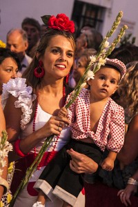 Una mujer sostiene a su pequeño mientras contempla la ofrenda. / Foto: Javi Losa.