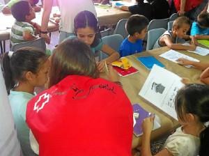 Los voluntarios de Cruz Roja con niños que han participado en este programa.