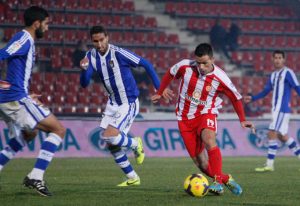 Felipe Sanchón intenta el remate ante la oposición de Menosse y Montoro. / Foto: Diari de Girona.