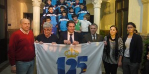 Autoridades locales, dirigentes del Recre, con la bandera, con algunos niños de la Escuela de Fútbol al fondo.