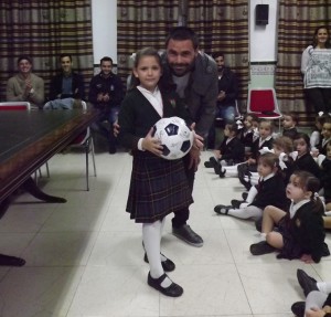 El capitán Córcoles entregando un balón a una alumna.