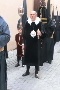 Con semblante serio, el muñidor marcaba el inicio del cortejo.