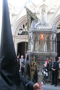 De ruán negro, con unos capirotes alargados y puntiagudos y con cirios oscuros avanzaba el cortejo por la calle Rábida de camino hacia la Iglesia de la Concepción. 