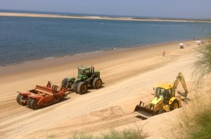 Trabajos de redistribución y perfilado de la arena en la playa de Nuevo Portil. 