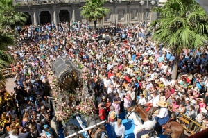 El Simpecado de Emigrantes rodeado por los ciudadanos en su salida hacia la aldea.