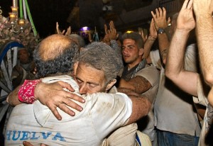 Dos romeros se abrazan a su llegada a la aldea. / Foto: Julián Pérez.