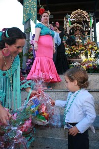 Un pequeña lleva su ofrenda al Santo.