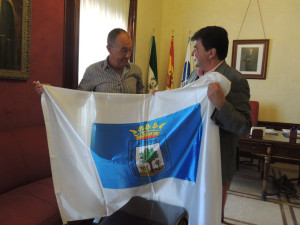 Cruz entrega a Ruiz una bandera de Huelva.