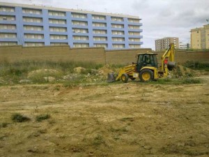 Una máquina realiza labores de limpieza en un solar de la capital.