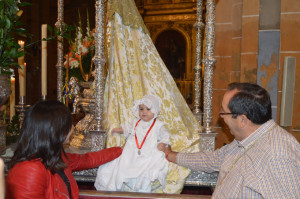 Un bebé, en el manto de la Virgen.