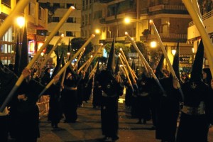 El silencio marca el caminar de la cofradía por el centro de Huelva.