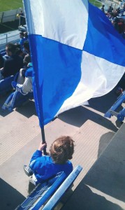 Roque, con una bandera blanquiazul, animando al Recreativo.