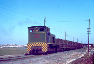 Tren de mineral de la Compañía de Cobre y Azufre de Tharsis, hacia los años 90 del siglo XX. Al fondo, Huelva. 