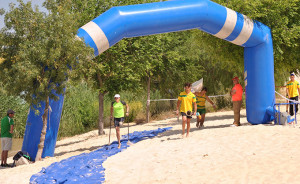 María del Mar González, que alcanzó el bronce, es ayudada por sus compañeros en los porteos por la arena.