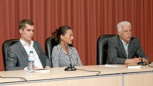 En la mesa de presentación está con la vicedecana de estudiantes y un compañero de estudios.