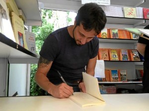 El escritor, firmando ejemplares de su novela en la Feria del libro de Madrid. 