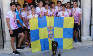 Los campeones con la bandera de Moguer en el acto de homenaje.