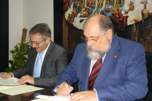 El decano del Colegio de Economistas de Huelva con el rector de la Universidad, firmando un convenio.