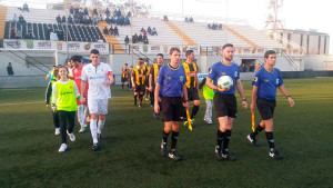 Los jugadores del AD Ceuta y el San Roque, y los árbitros, en el momento de saltar al terreno de juego. / Foto: @ElFarodeCeuta.