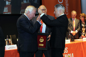 El presidente del Colegio de Economistas de España le hace entrega de la medalla de oro a José Luis García Palacios.