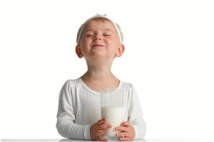 Una niña feliz con su vaso de leche. 