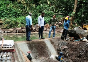 Revisando una captación de agua para el distrito de Basakato de la Sagrada Familia.