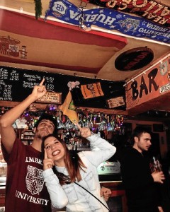 Tamara y Adrián, orgullosos de Huelva y el Recreativo, junto a la bandera del Decano colgada en un establecimiento británico.