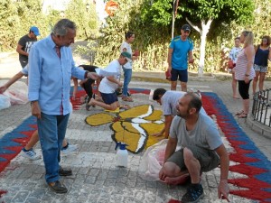 Trabajando en la realización de alfombras de serrín teñido con motivo de la celebración del Corpus en Hinojos.