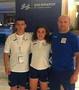 Pablo Pereira y Natalia Pereda, junto al entrenador Veaceslav Cepeleaga, en Budapest. / Foto: @luchaelcampeon.