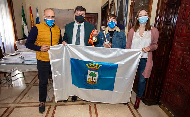 El alcalde Gabriel Cruz entregó a Daniel Marín la bandera de Huelva y le felicitó por el triple oro conseguido.