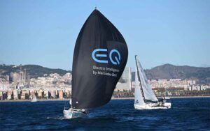 El 'Mercedes-Benz Sailing Team' en plena empopada con la Ciudad Condal al fondo. / Foto: Óscar Torrades/Torveo Photo.