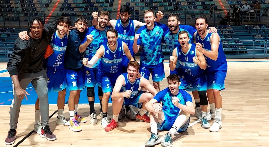 Los jugadores del Ciudad de Huelva celebran en el centro de la pista del 'Carolina Marín' su triunfo ante el CB San Fernando. / Foto: @CiudadDeHuelva.