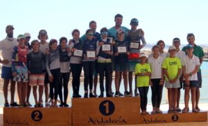 Podio del Campeonato de Andalucía por Equipos de Óptimist con los regatistas del RCMTPU en el primer puesto del cajón. / Foto: www.fav.es.