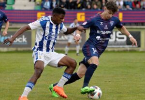 Peter y Plomer pugnan por un balón en el partido de este domingo en La Albuera. / Foto: @recreoficial.